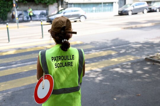 Agente de patrouille scolaire vue de dos pr&egrave;s d&rsquo;un passage pi&eacute;ton