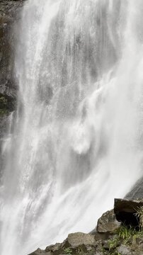 Close-up vertical shot of water streams falling from a cliff.