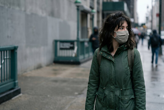 Young woman wearing protective face mask walking on urban city street