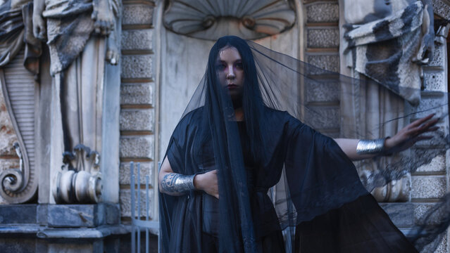 Dark sorceress in flowing veil and silver bracers, gothic fantasy and magic ritual concept.