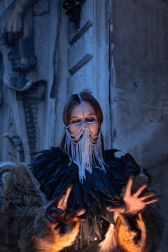 Mystical woman in a silver chain veil reaching out with her hands, occult ritual concept