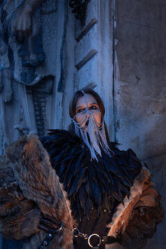 Anonymous woman hiding her face behind a silver chain veil and black cape. Concept of mystery