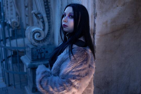 Woman in a warm fluffy fur coat on a cold street, winter fashion and dark makeup