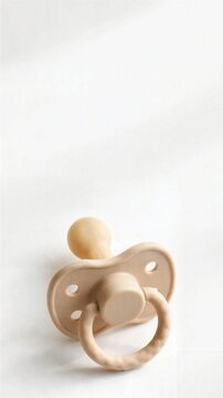 Baby Pacifier on Minimal White Fabric Background