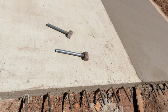 Construction sledges on concrete paving with exposed steel rebar dowels