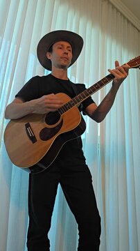 homem tocando viol&atilde;o em casa 