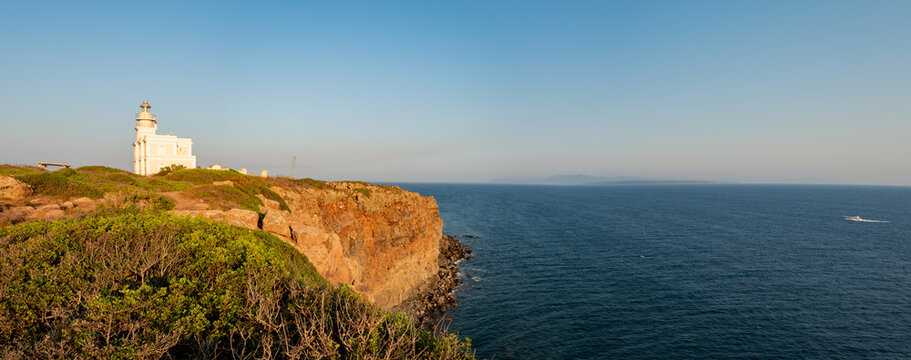 Lighthouse, panorama of the San Giovanni in Sinis promontory, sea view at sunset, in the municipality of Cabras, Italy.