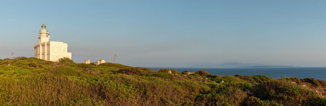Lighthouse, panorama of the San Giovanni in Sinis promontory, sea view at sunset, in the municipality of Cabras, Italy.