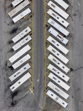 Aerial view of the bus terminal with rows of parked white buses arranged in a herringbone pattern on asphalt in Coimbra, Coimbra, Portugal.