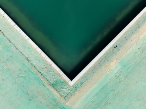 Aerial view of the corner of a pool at Ocean Reef Boat Harbour with turquoise water and sandy ground in Ocean Reef, Western Australia, Australia.