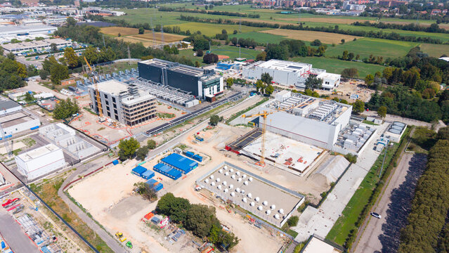 Aerial view of the Equinix ML5 data center construction site featuring large industrial buildings, active cranes, and site infrastructure in Castelletto, Lombardia, Italy.