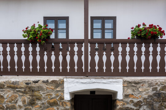 Detail of traditional House with Wooden Balcony and Geraniums in Holl&oacute;kő, Hungary.