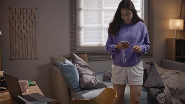 Caucasian young woman waking up, checking smartphone, sitting at desk to work on laptop while eating breakfast. Video ideal for commercial use in remote work and digital burnout campaigns