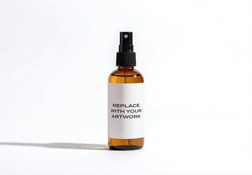 Glass spray bottle mockup with label template on a surface, minimalist product presentation for branding and packaging design, studio shot soft lighting clean background