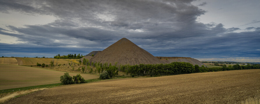The distinctive slag heap of the Brosowski shaft in Mansfelder Land under a wide cloudy sky, industrial heritage in Saxony-Anhalt