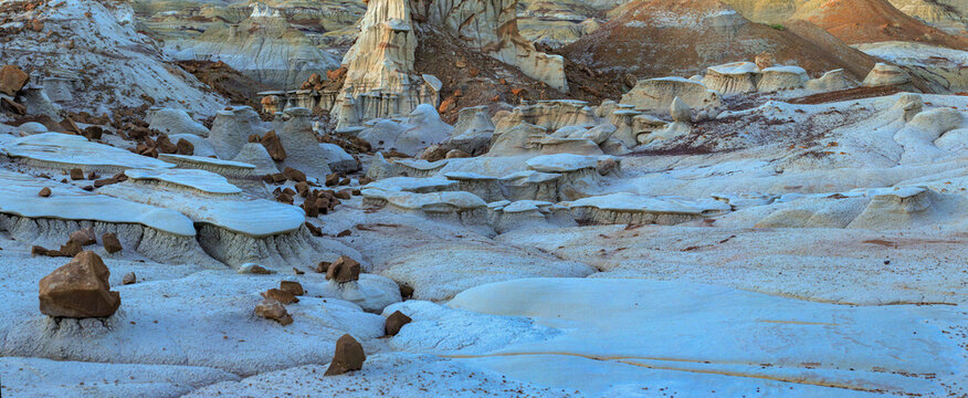 Beautiful wide panoramic view of unique badlands desert rock formations with caprocks at sunset