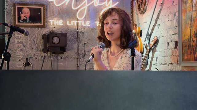 Recognizable Female Performance Artist and Vocal Performer Emotionally Expressing Herself on Stage in a Retro Club Interior holding Microphone with Audience POV and Handheld Camera Vibe Shot