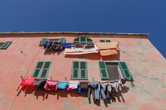 Washing hanging to dry outside colourful building, Imperia, Italy