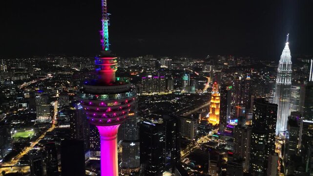 Pass by shot of illuminated Kuala Lumpur telecommunication tower at nighttime, Malaysia.
