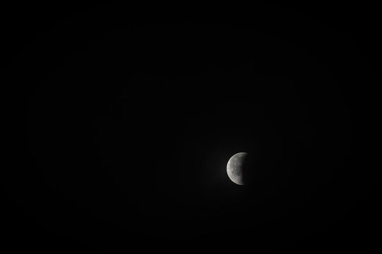 View of a partial lunar eclipse with the moon partially obscured by the Earth's shadow in the night sky over Jahanian, Pakistan.