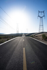 Naklejka premium highway power transmission towers under bright sun
