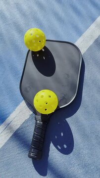 Pickleball paddle and yellow balls on a blue court