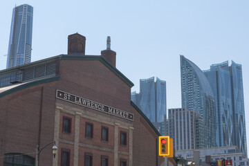 Obraz premium contrast of architectural eras: (left) St Lawrence Market, 1902, with 1845 Toronto City Hall facade and contemporary architecture including (above) Skytower and a cluster of buildings near the financi