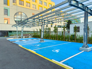 Parking area with marked spots under a structure for shade located in an urban environment during...