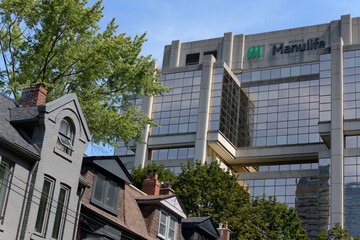 Obraz premium historic row houses on Asquith Av and exterior building and sign of Manulife Financial Headquarter, Toronto