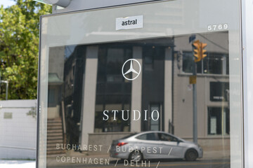 Obraz premium out-of-home Astral Media bus shelter with advertising poster for Mercedes-Benz Studio (retail/brand experience) in Toronto (shows reflection of street scene)