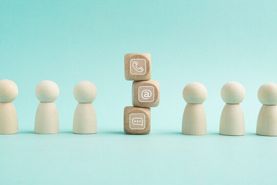 Wooden blocks on table showing phone, email, address and live chat icons. Contact us about customer service center connectivity concept. Internet communication via website