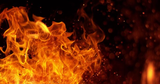 Ultra slow motion fire flames with glowing embers and sparks on black background captured at 1000 FPS. Dramatic combustion effect ideal for cinematic overlays and visual effects.