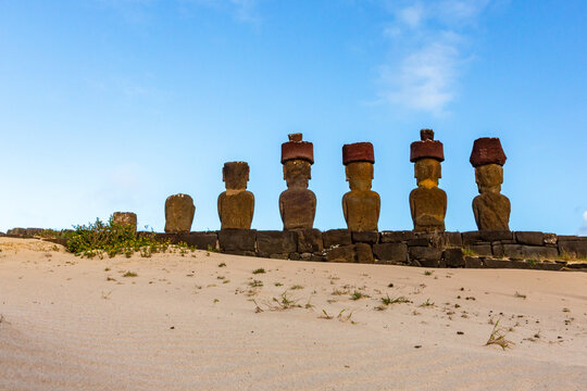 View of the Moai statues at Ahu Nua Nua on Anakena Beach, set on a stone platform against a clear blue sky in Easter Island, Valparaiso, Chile.