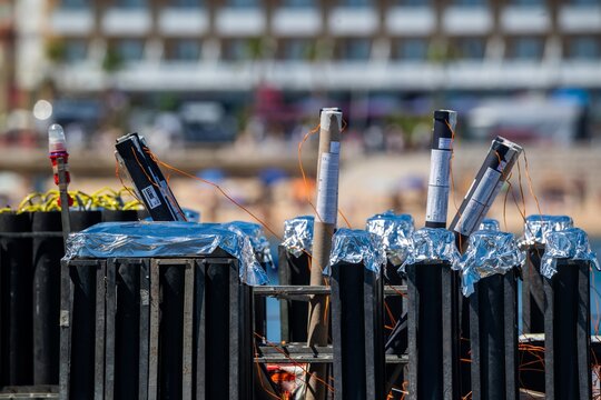 View of fireworks launch tubes arranged in a rack with foil-covered tops and electrical wiring, set up for a display in Cascais, Lisbon, Portugal.