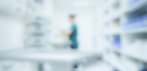 Fototapeta premium A blurred image of a healthcare professional working in a medical storage area, surrounded by shelves filled with medical supplies and equipment.
