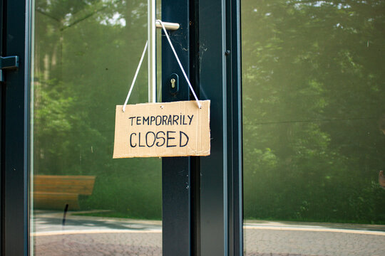 TEMPORARILY CLOSED notice on cafe entrance. Small business closes due to Financial struggles. High prices cause customer falling