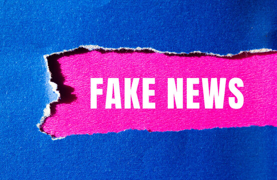 Fake news message written on ripped torn paper background. Conceptual Fake news symbol. Copy space.