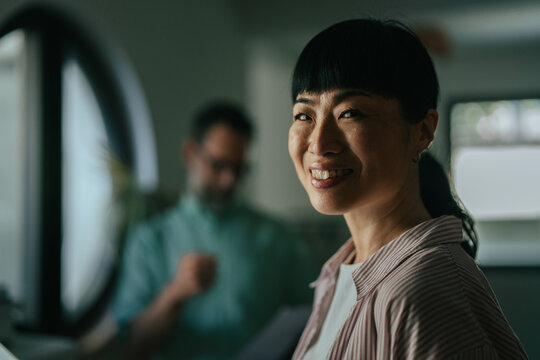 Asian woman smiling with confidence in office