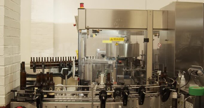 Beer bottles on automated bottling machine in brewery Berlin