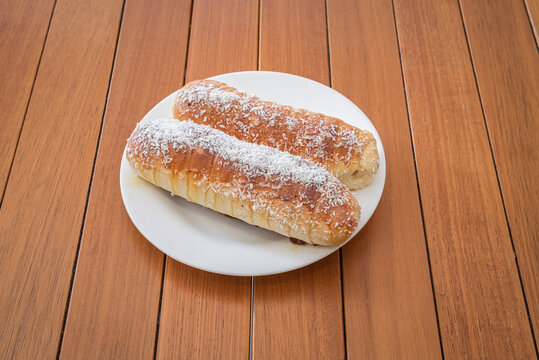 Two Brazilian enroladinho de queijo cheese and coconut Bread Rolls on Plate