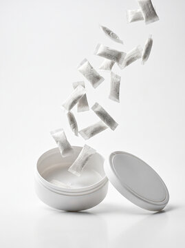 White Snus Pouches Falling into an Open Round Tin