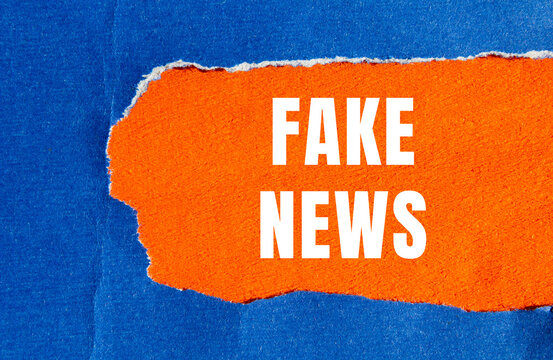 Fake news message written on ripped torn paper background. Conceptual Fake news symbol. Copy space.