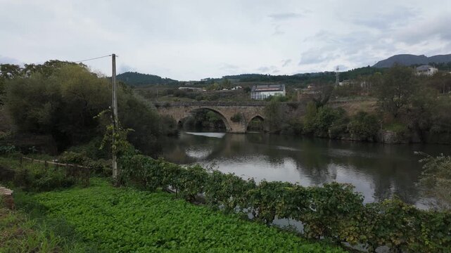 Scenic view along the Sil River near Ponte da Cigarrosa, with calm water, green riverbanks and rural hills surrounding Pet&iacute;n and A R&uacute;a de Valdeorras in the scenic countryside of Galicia, Spain