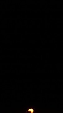 A tall candle flame burns steadily against a dark background, flickering gently before gradually shrinking, dimming, and fading completely into darkness near the end.
