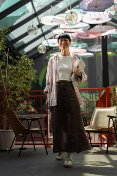Asian woman walking smiling in modern coworking office