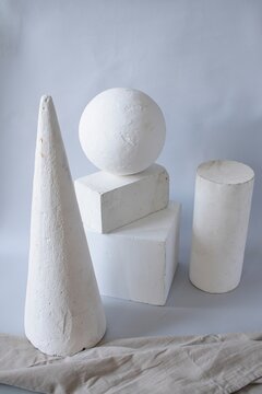 Geometric shapes and decorative bracket arranged on a neutral background. Still life made of plaster molds for teaching drawing in art school. Back to school concept.