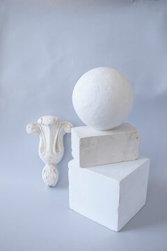 Geometric shapes and decorative bracket arranged on a neutral background. Still life made of plaster molds for teaching drawing in art school. Back to school concept.