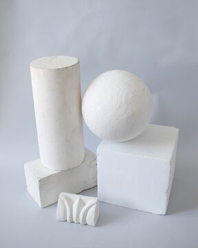 Geometric shapes and decorative bracket arranged on a neutral background. Still life made of plaster molds for teaching drawing in art school. Back to school concept.