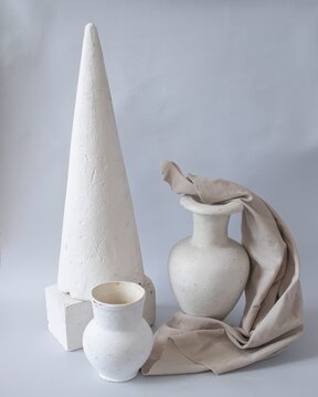Geometric shapes and decorative bracket arranged on a neutral background. Still life made of plaster molds for teaching drawing in art school. Back to school concept.