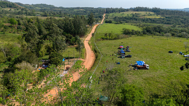 Aerial view of Rally Paraguay spectators camping along a dirt road in the countryside of Nueva Alborada, Itapua Department, Paraguay.